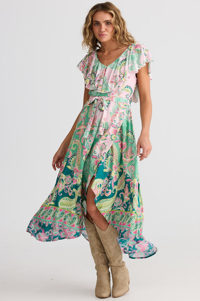 Woman wearing a floral dress with ruffled neckline on a white background