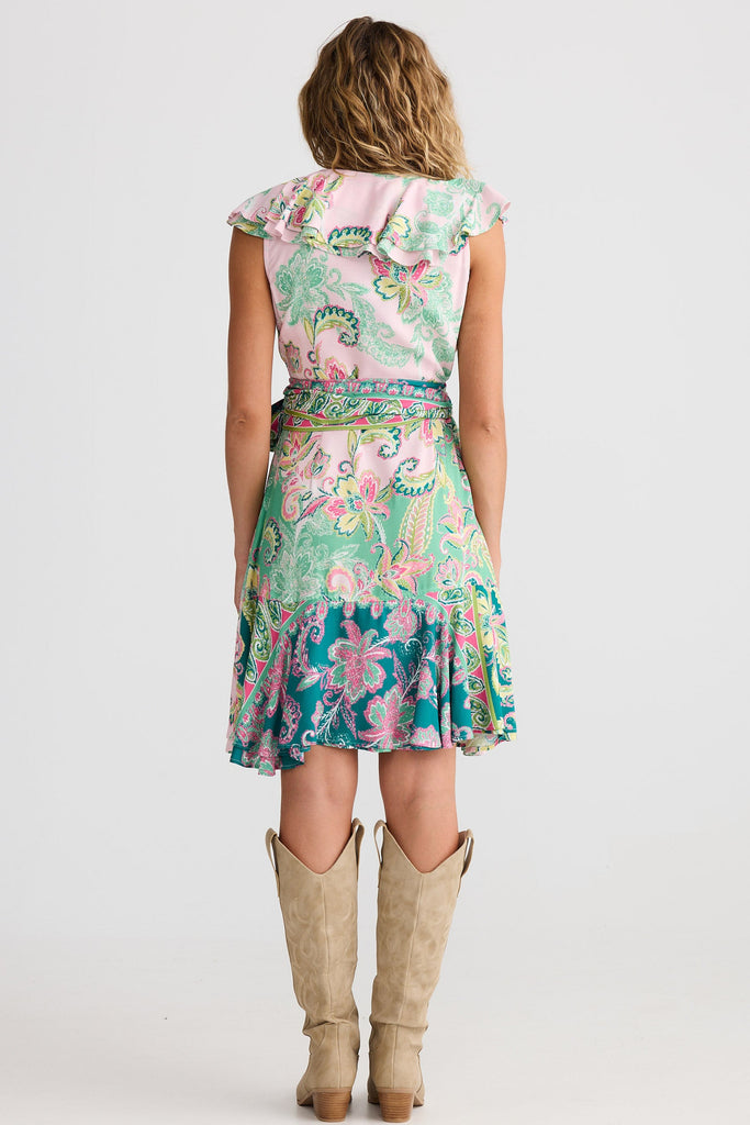 Woman wearing a floral dress and tan boots on a white background