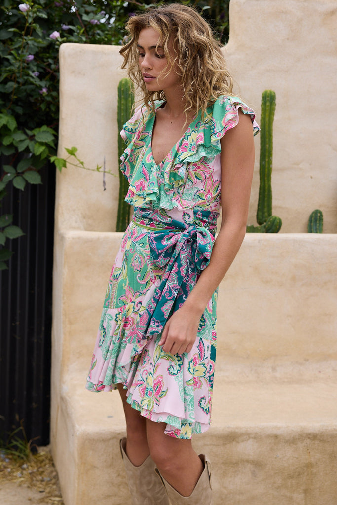 Woman in a floral dress standing outdoors with cacti in the background