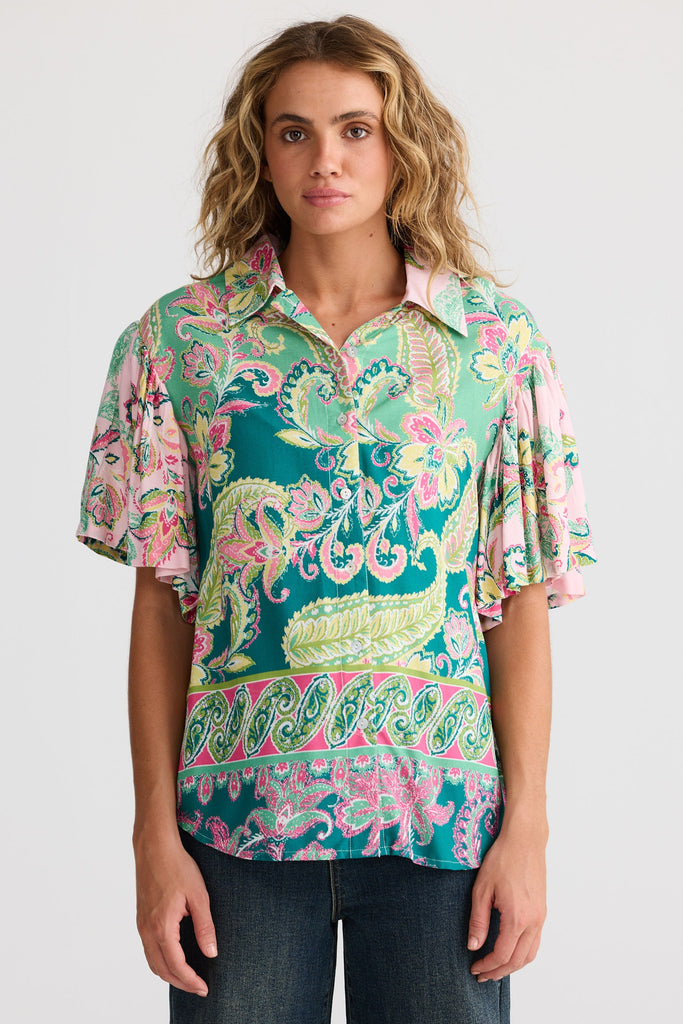 Woman wearing a colorful patterned shirt on a white background