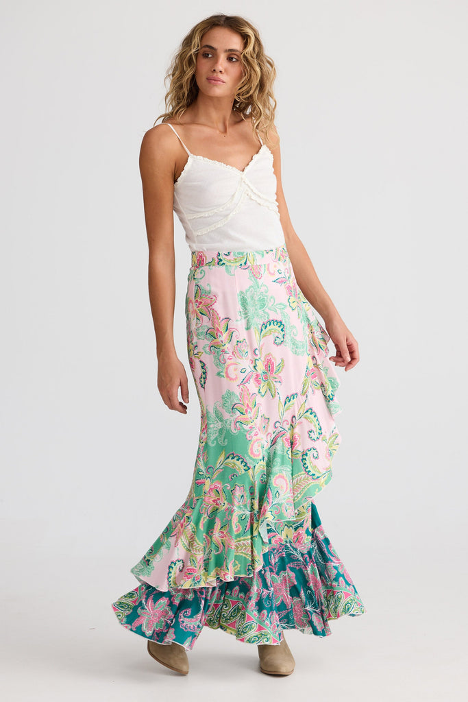 Woman wearing a floral skirt and white top on a white background