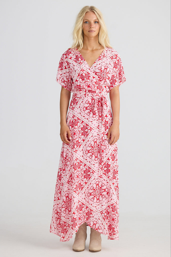 Woman wearing a red and white patterned dress on a white background