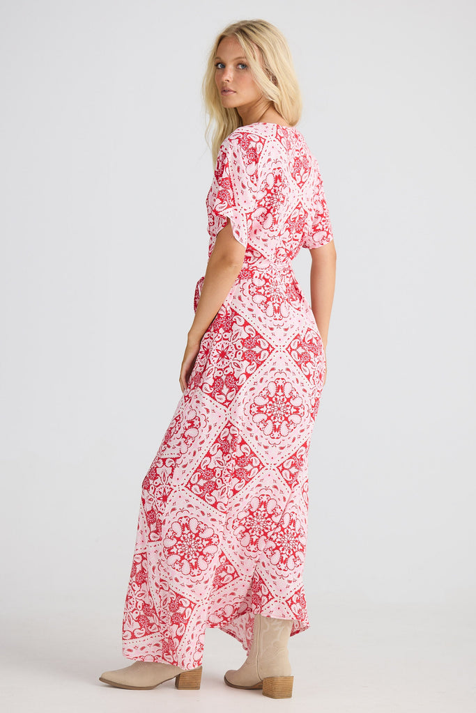 Woman wearing a red and white patterned dress on a white background