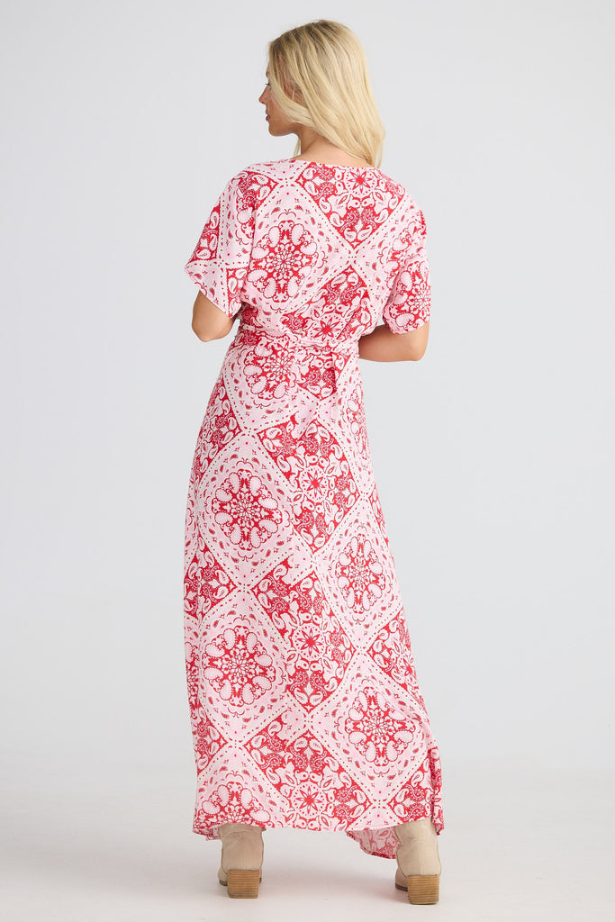 Woman wearing a red and white patterned dress on a white background