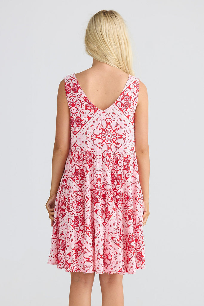 Woman wearing a red and white patterned dress on a white background