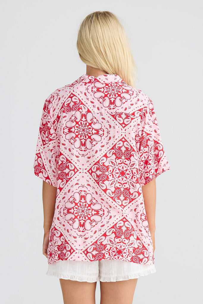 Woman wearing a red and white patterned shirt on a white background