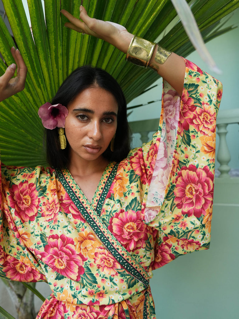 Woman wearing a colorful floral outfit with a green background