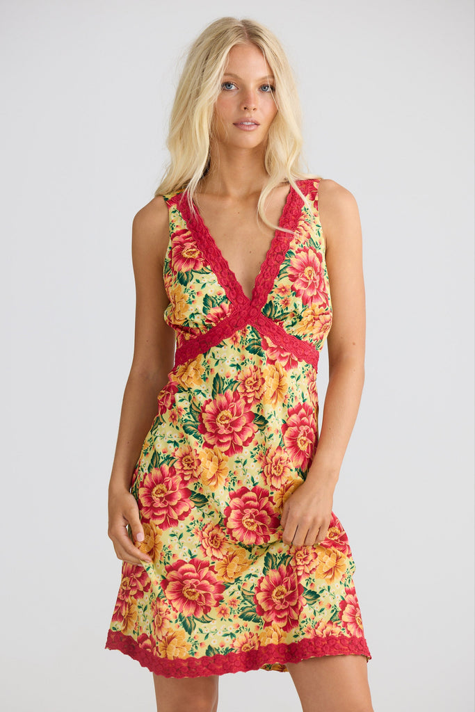 Woman wearing a floral dress with a red border on a white background