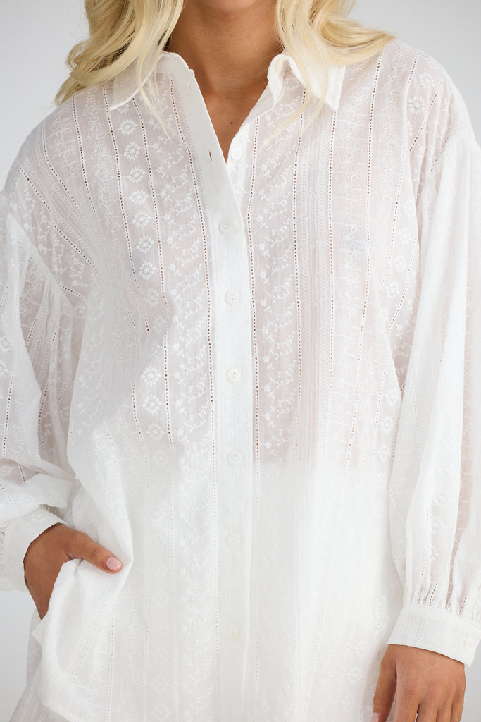 White embroidered blouse worn by a person on a white background