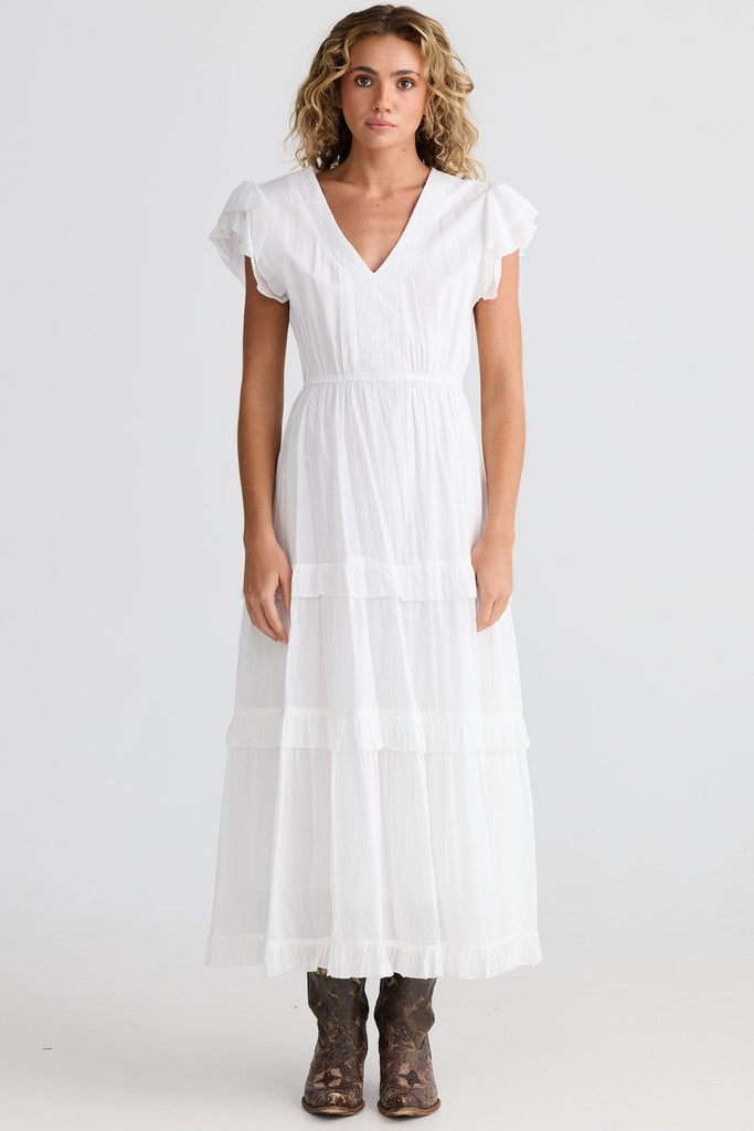 Woman wearing a white dress on a plain background