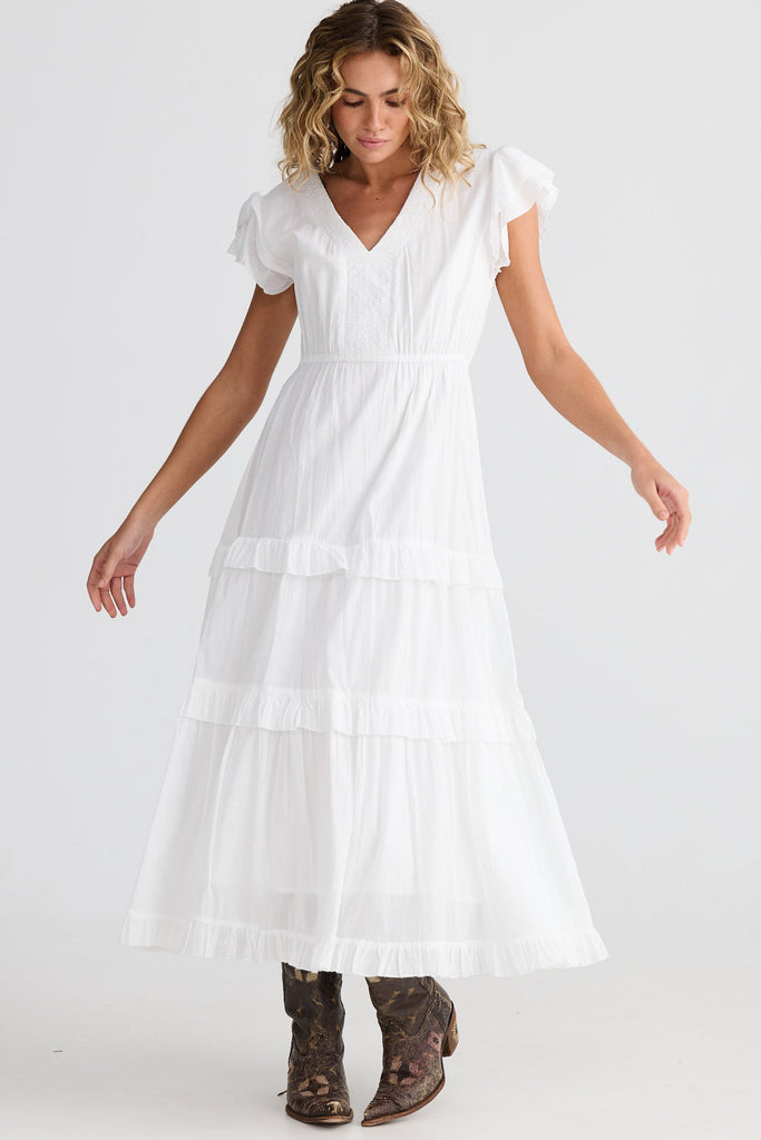 Woman wearing a white dress on a plain background