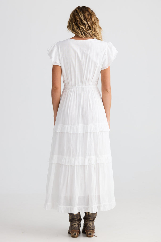 Woman wearing a white dress with a plain background