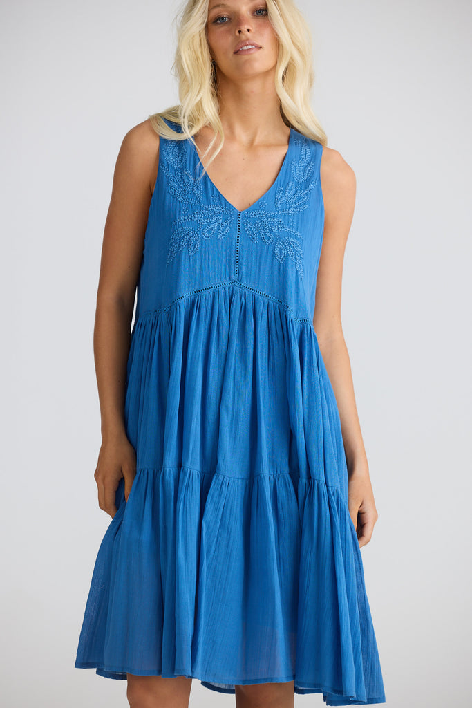 Woman wearing a blue dress against a white background