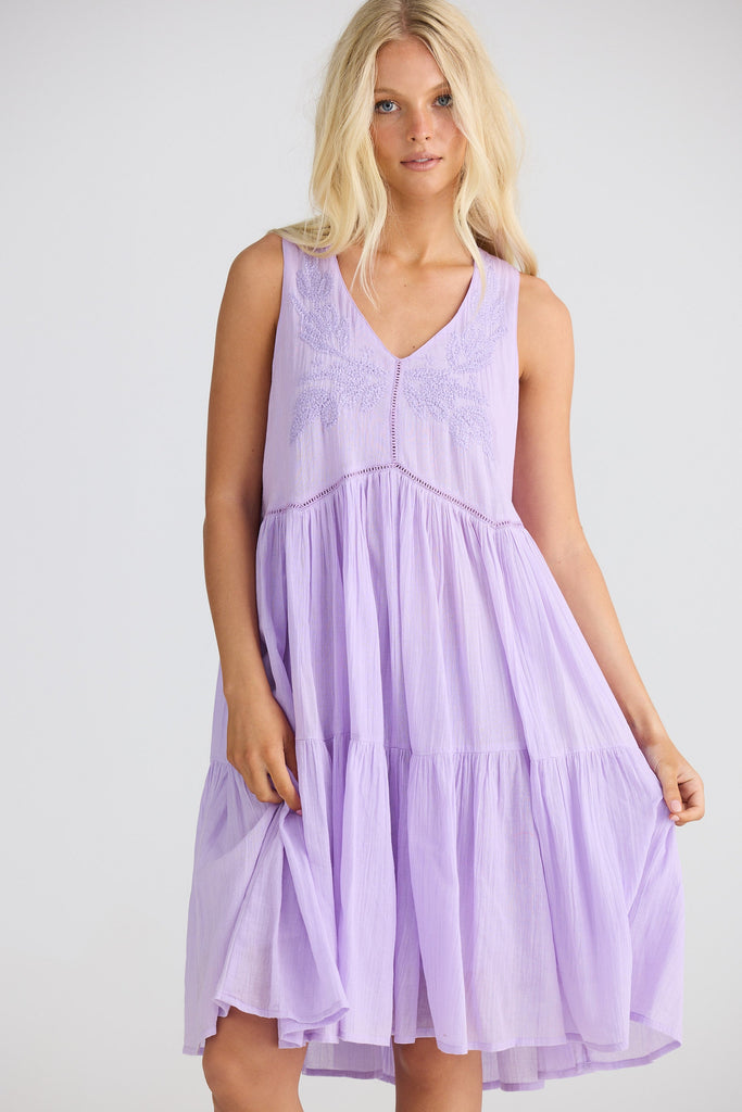 Woman wearing a light purple dress against a white background