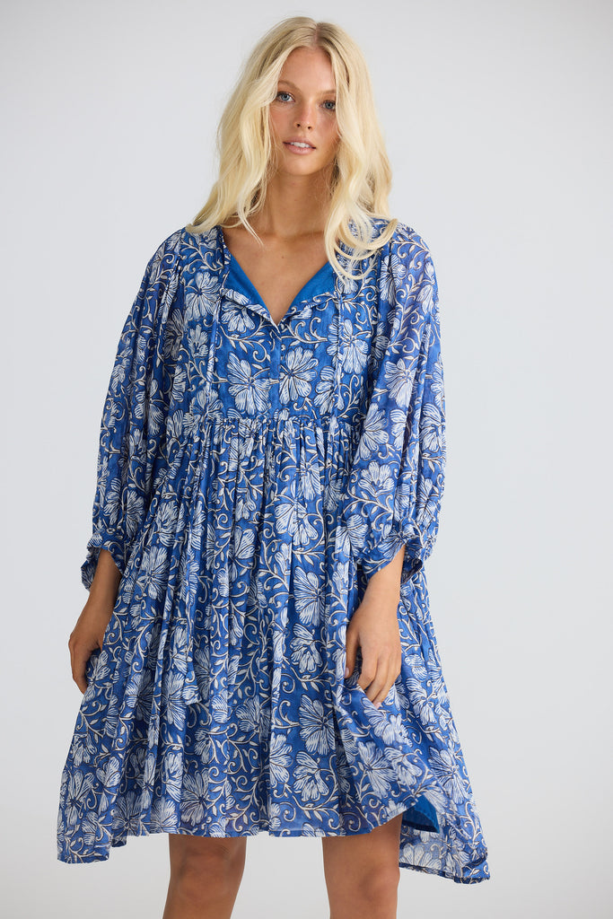 Woman wearing a blue floral dress on a white background