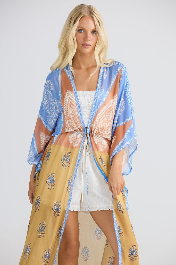 Woman wearing a colorful kimono-style garment with a white background