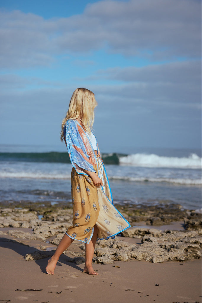 Woman walking on a beach with ocean waves in the background