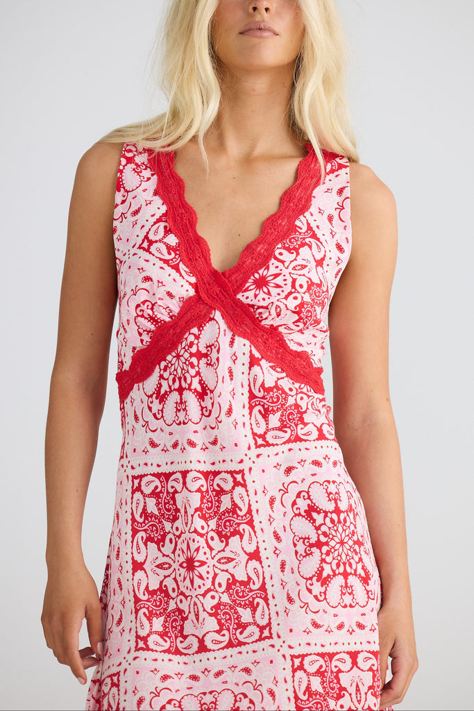 Woman wearing a red and white patterned dress on a plain background