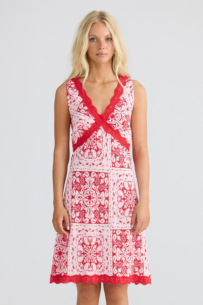 Woman wearing a red and white dress n a light gray background