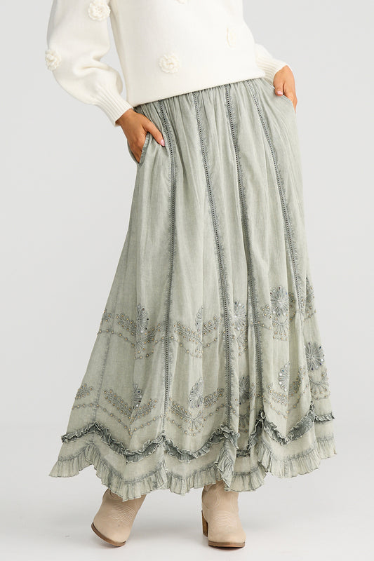 Long, patterned skirt worn by a person on a plain background