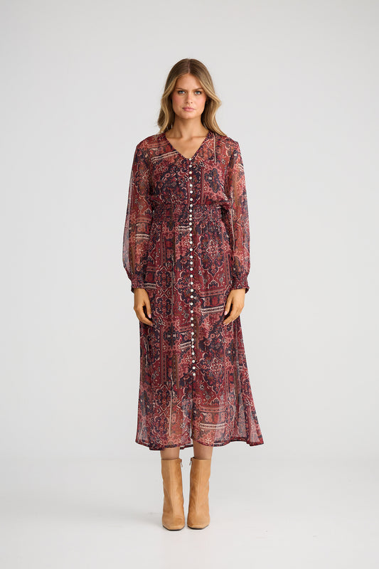 Woman wearing a patterned dress on a white background
