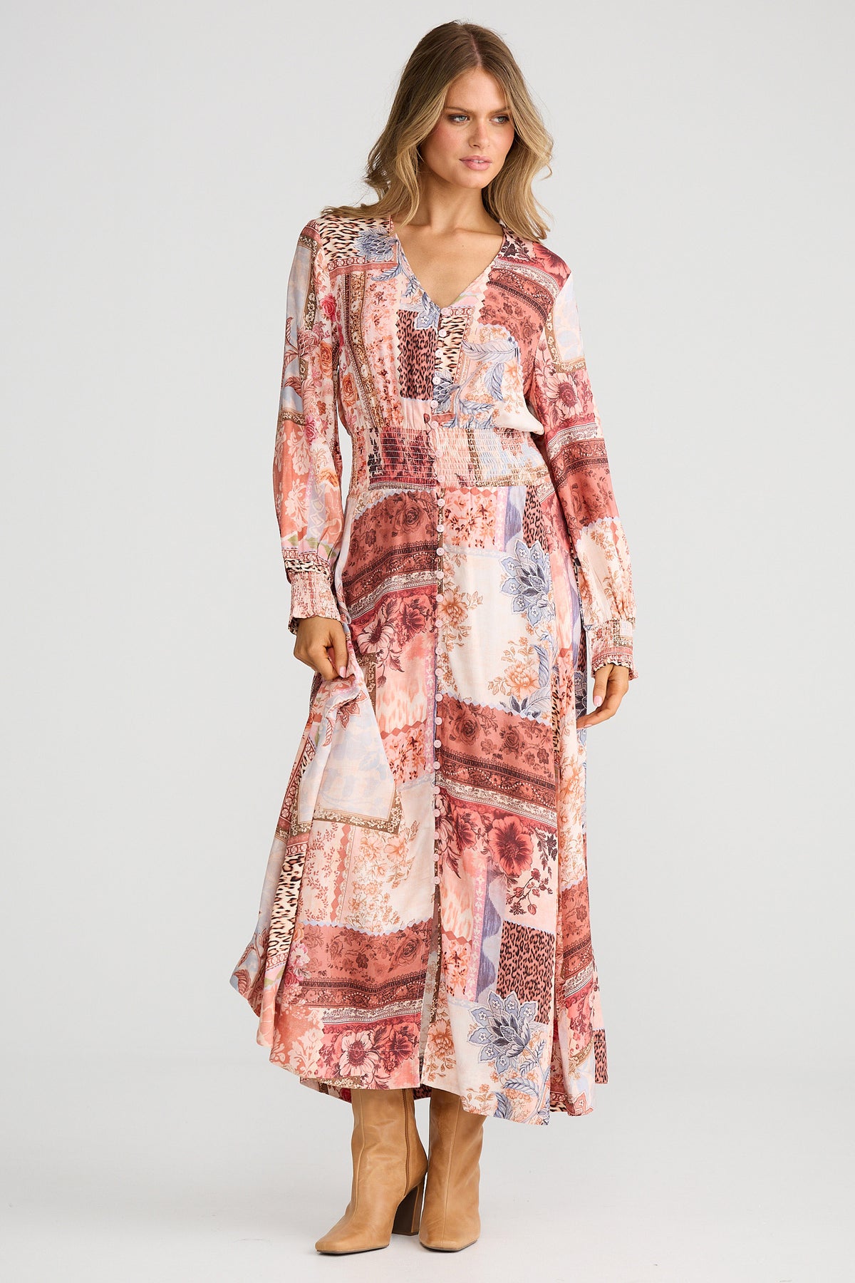 Woman wearing a patterned dress with long sleeves on a white background