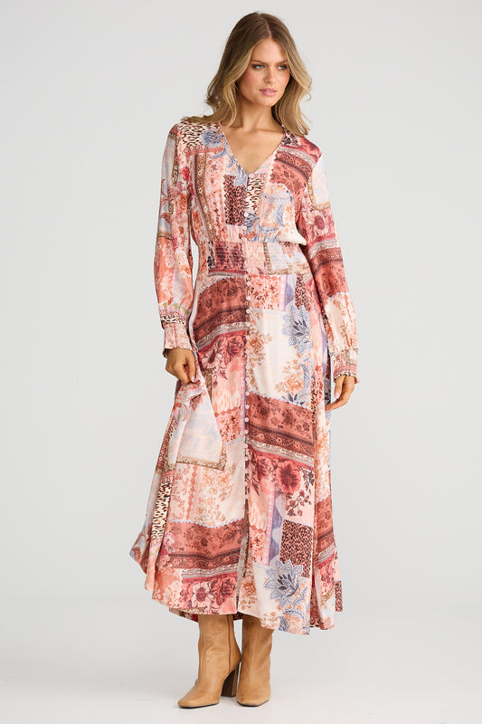 Woman wearing a patterned dress with long sleeves on a white background