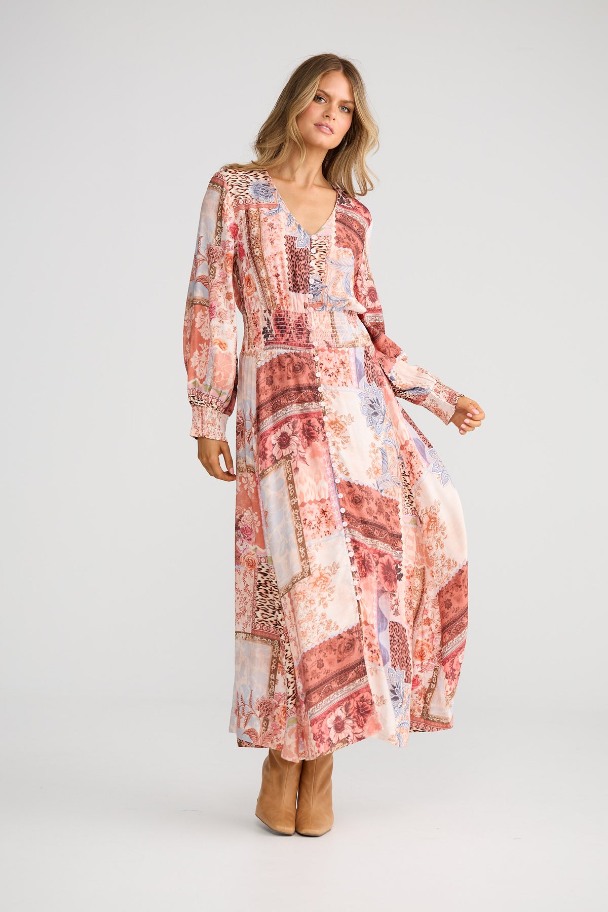 Woman wearing a long, patterned dress on a white background