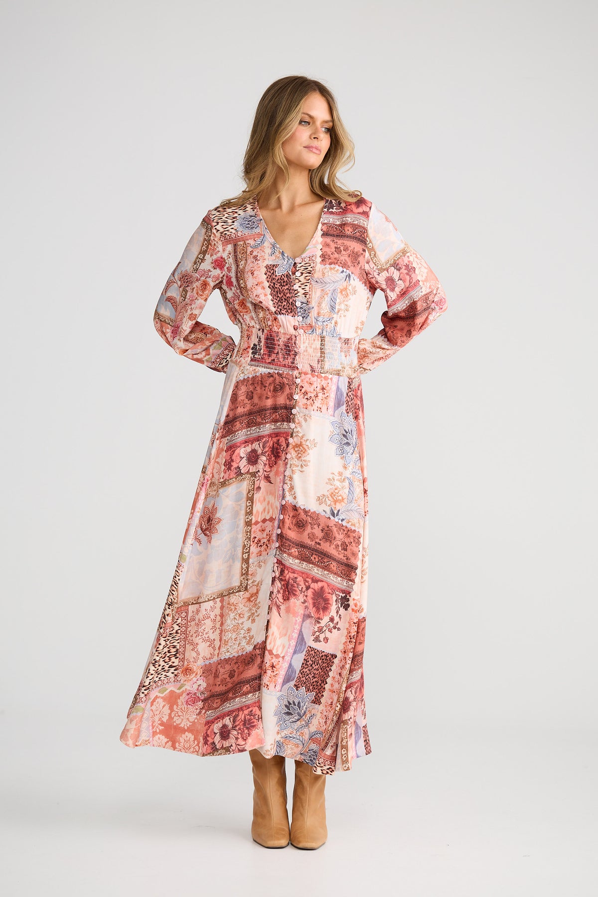 Woman wearing a long, patterned dress on a white background