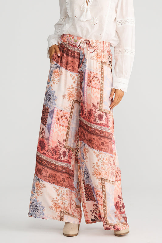 Floral patterned pants worn by a person on a white background