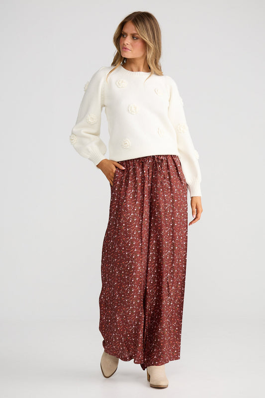 Woman wearing a white blouse and red patterned skirt on a white background