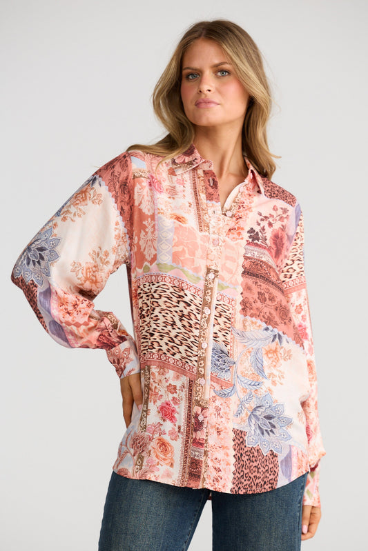 Woman wearing a patterned blouse with a plain background