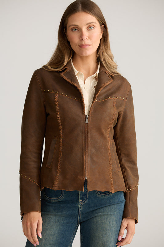 Woman wearing a brown leather jacket with decorative stitching on a plain background