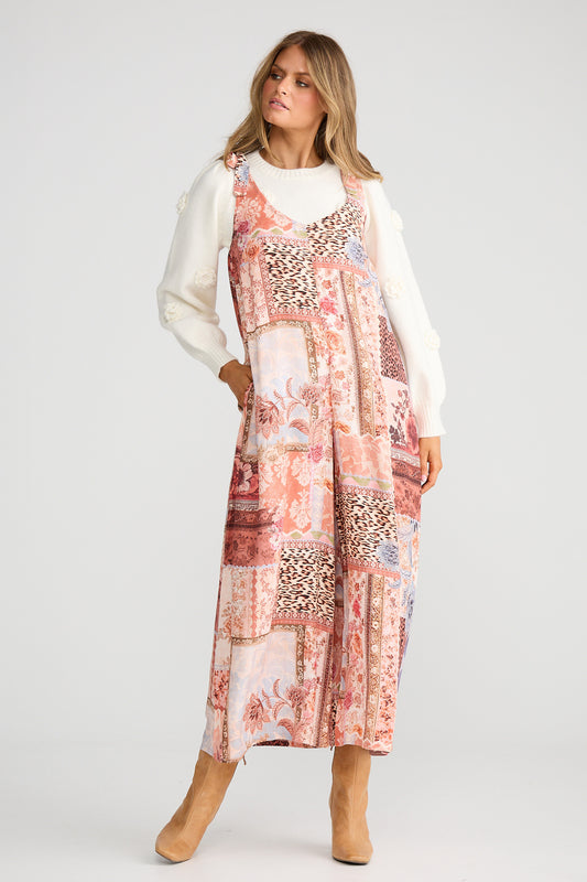 Woman wearing a patterned dress with a white cardigan on a white background