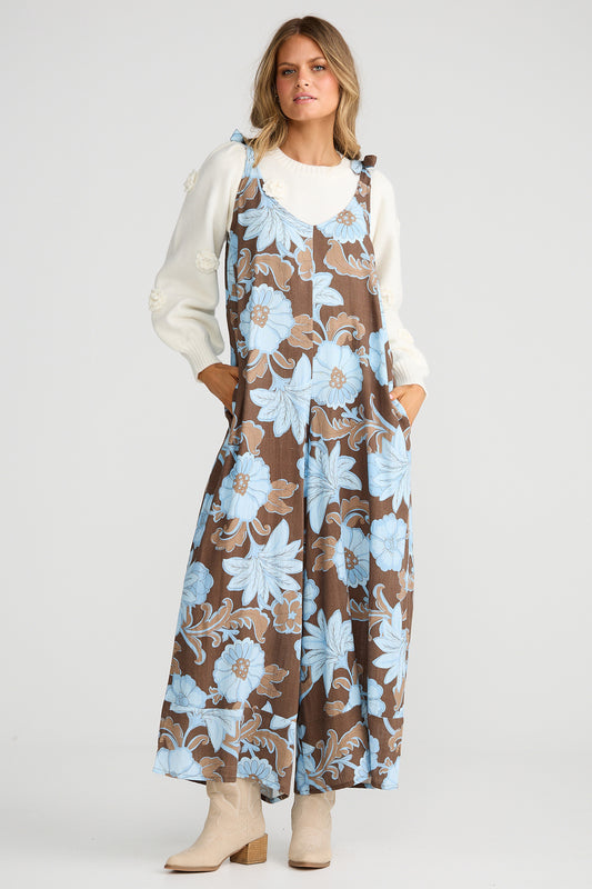 Woman wearing a floral dress over a white shirt on a plain background
