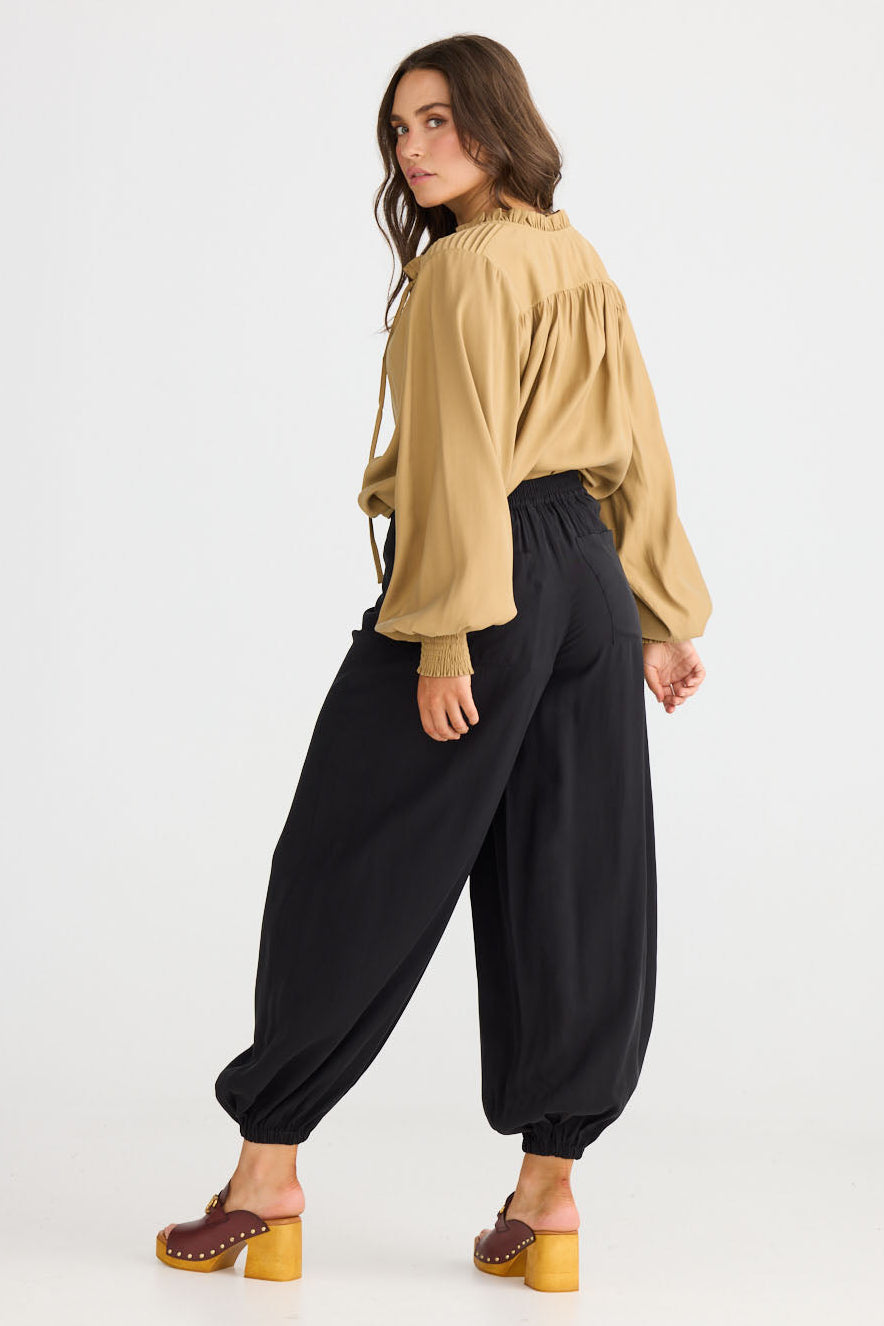 Model wearing Genie Pant in black with elasticated back waistband, back view on white background