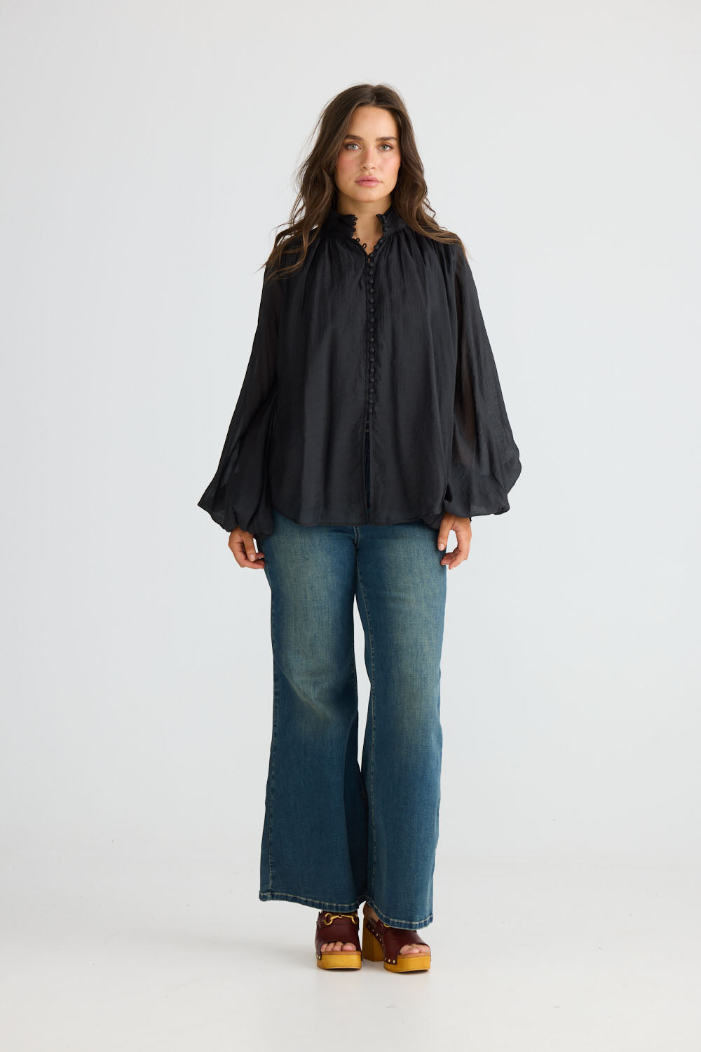 Close-up of Sylva Blouse in black showing high collar with ruched details, detail view on white background