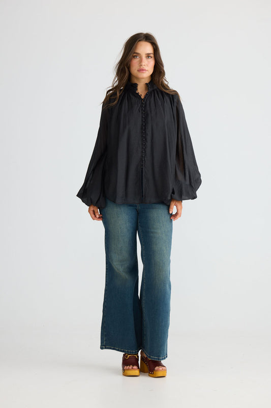 Close-up of Sylva Blouse in black showing high collar with ruched details, detail view on white background