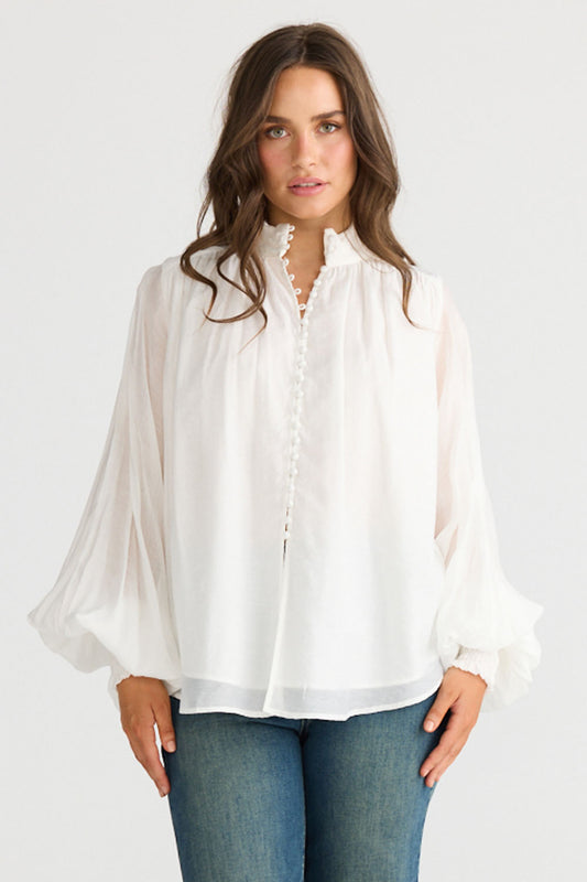 Model wearing Sylva Blouse in off white with high collar with ruched details, front view on white background