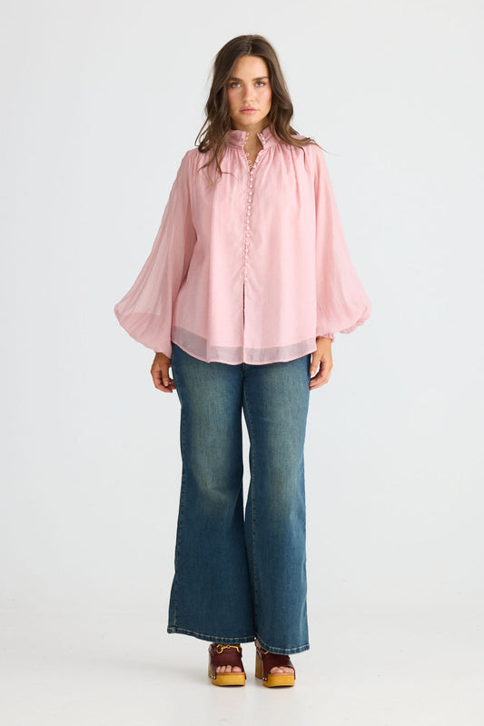 Model wearing Sylva Blouse in pink with high collar with ruched details, back view on white background