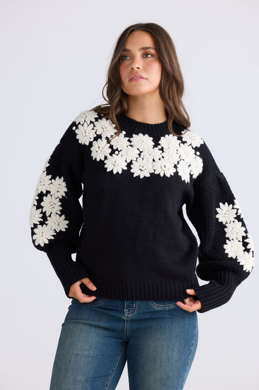 Close-up of Flower Child Knit in black and white showing round neckline and extra wide cuffs, detail view on white background