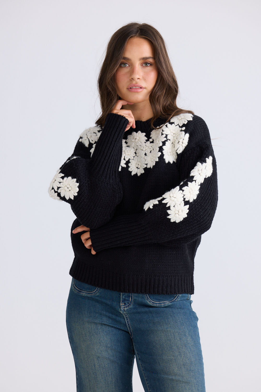 Model wearing Flower Child Knit in black and white with round neckline and extra wide cuffs, back view on white background