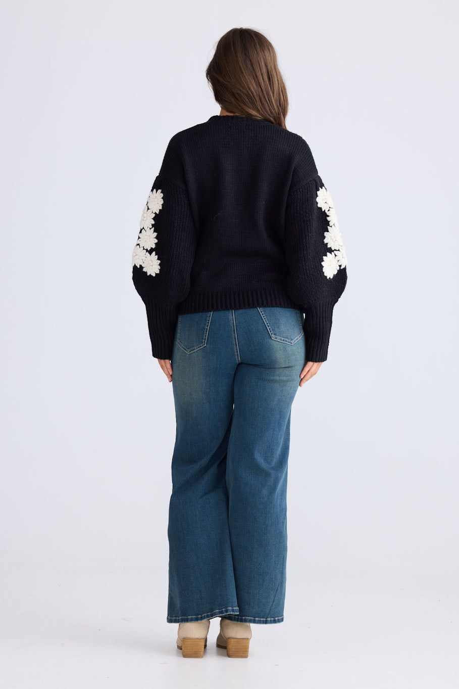 Model wearing Flower Child Knit in black and white with round neckline and extra wide cuffs, front view on white background