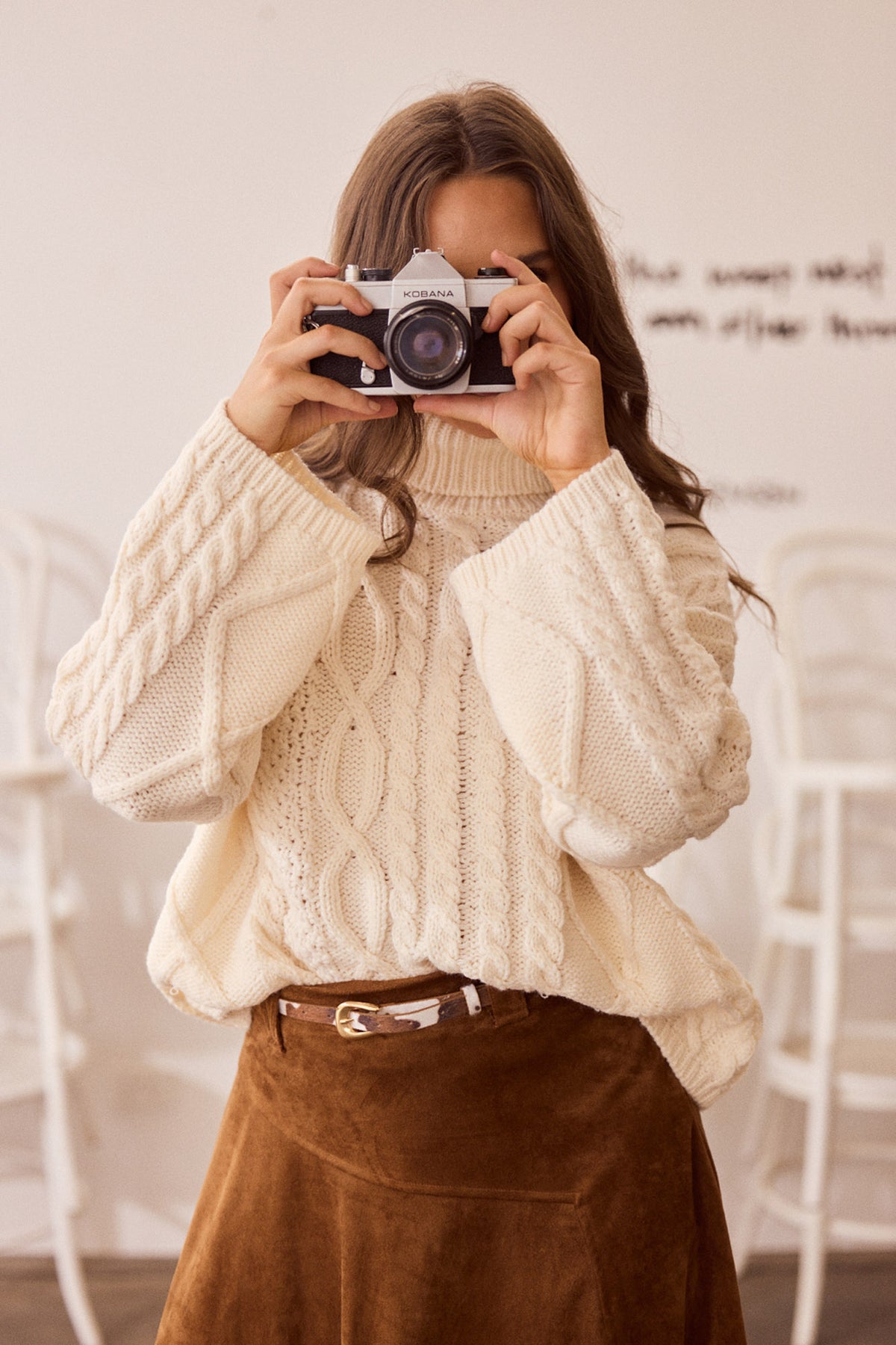 Close-up of Dixie Knit in cream showing roll-neck collar and cable knit design, detail view on white background