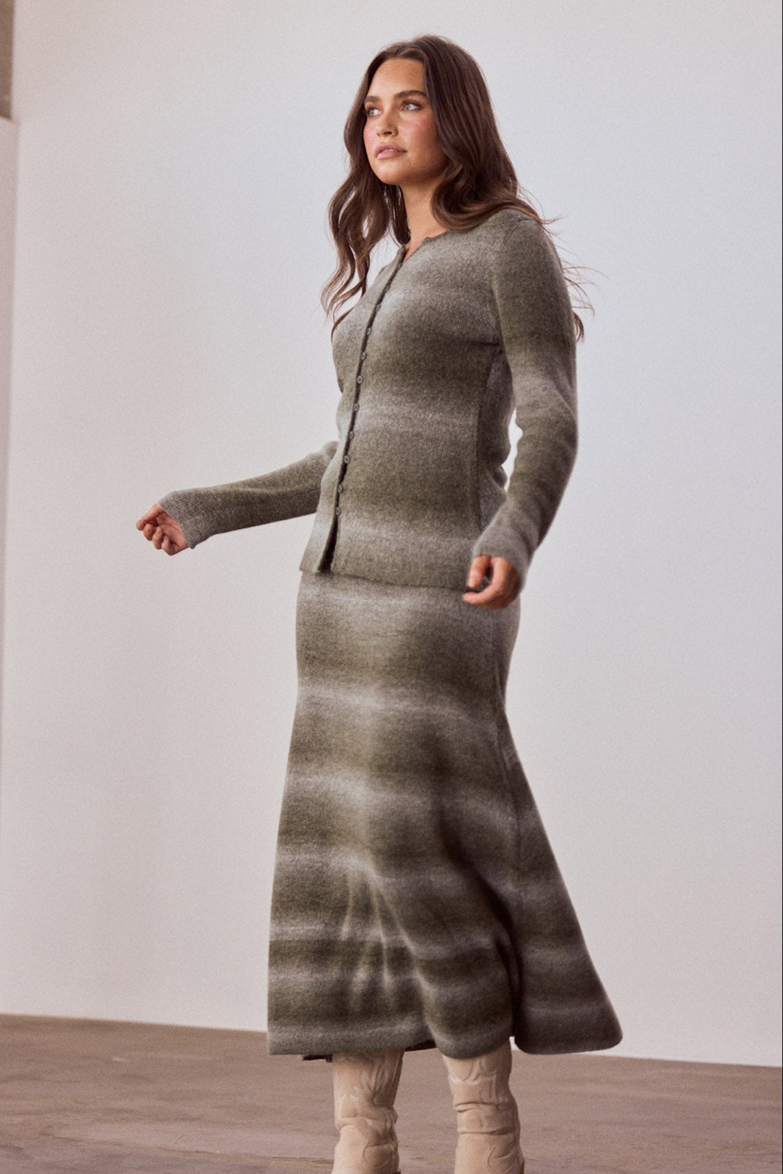 Model wearing Essence Knit Skirt in moss ombre with ombre knit design, side view on white background