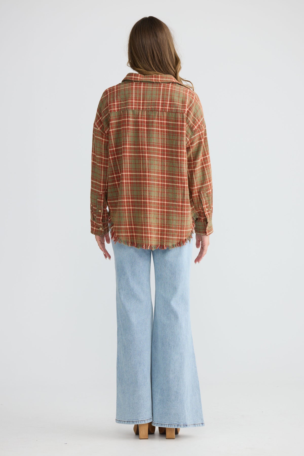 Model wearing Daytona Shirt in rust check with two-piece collar and long sleeves, back view on white background