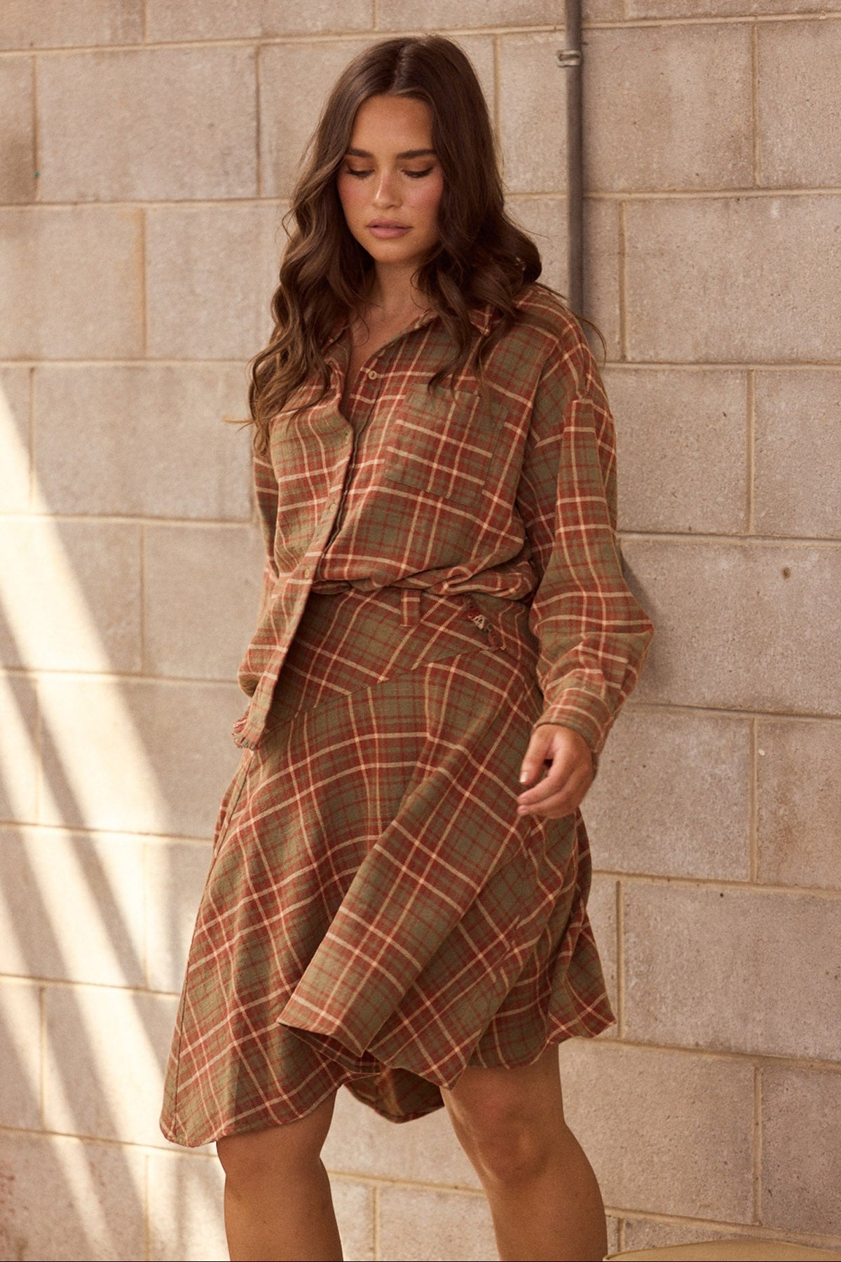 Model wearing Daytona Shirt in rust check with two-piece collar and long sleeves, back view on white background