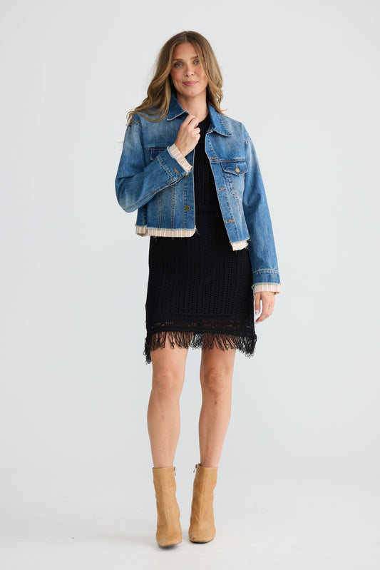 Close-up of Riverstone Jacket in mid blue wash showing classic denim silhouette, detail view on white background
