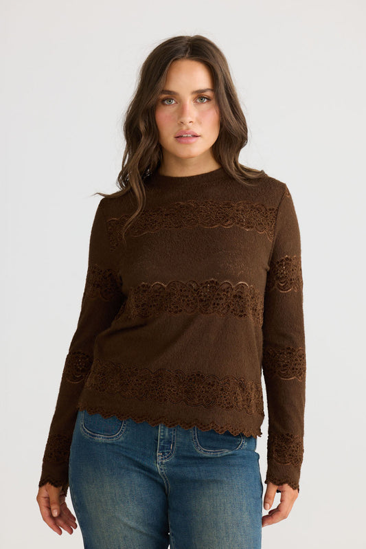 Model wearing Liora Top in chocolate with crew neckline and long fitted sleeves, front view on white background