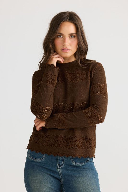 Close-up of Liora Top in chocolate showing crew neckline and long fitted sleeves, detail view on white background
